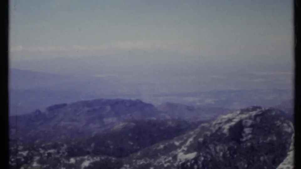 1971 California 8mm frame showing a broad hazy mountain view and a rocky outcrop along the right side.