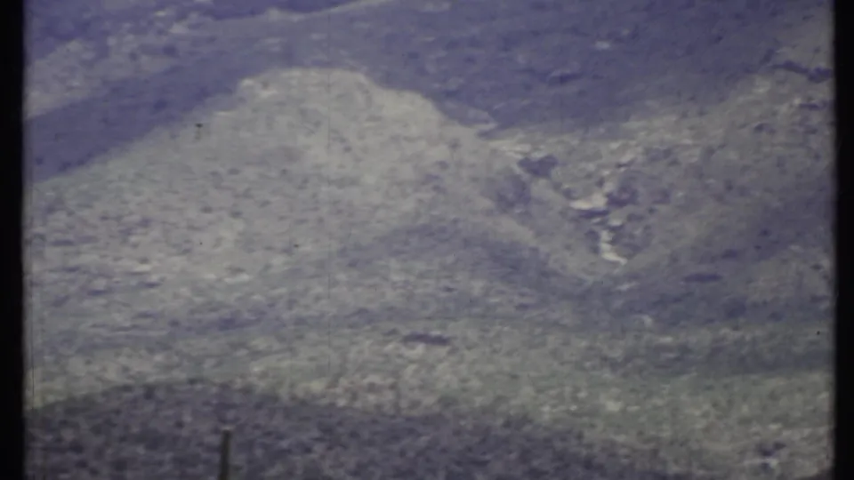 1971 8mm view of arid California hills, softly exposed with faded color and visible film wear.