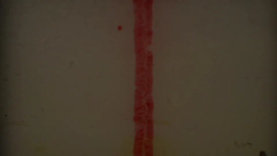 8mm film frame showing a dark blank section with a vertical red film mark and visible dust or processing artifacts.