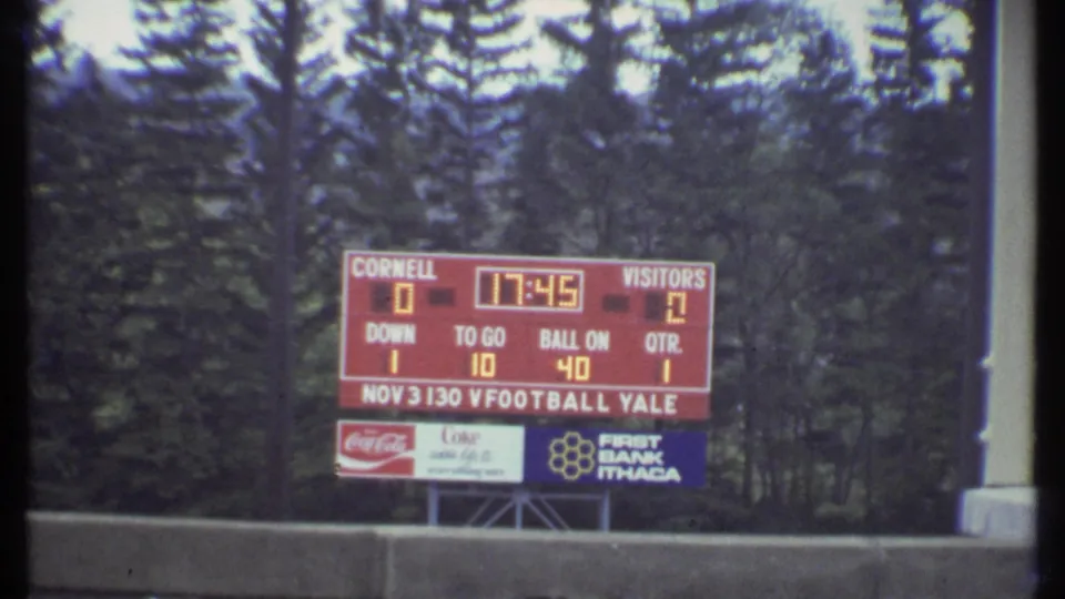 1979 Ithaca stadium scoreboard showing Cornell and visitors with Nov. 3 football text and sponsor signs below.