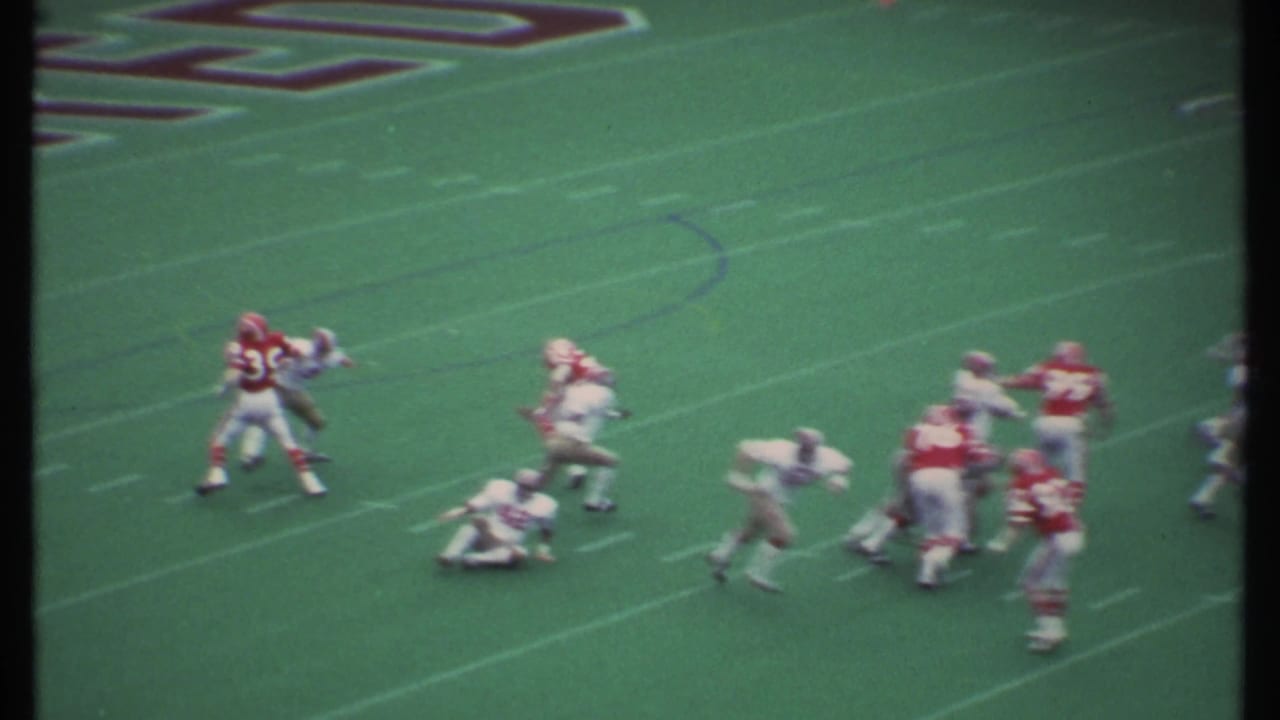 Football players block and tackle during a play on the field.