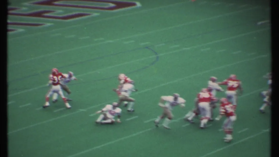 Players in red and white uniforms collide and block during a 1979 football play in Ithaca, New York.
