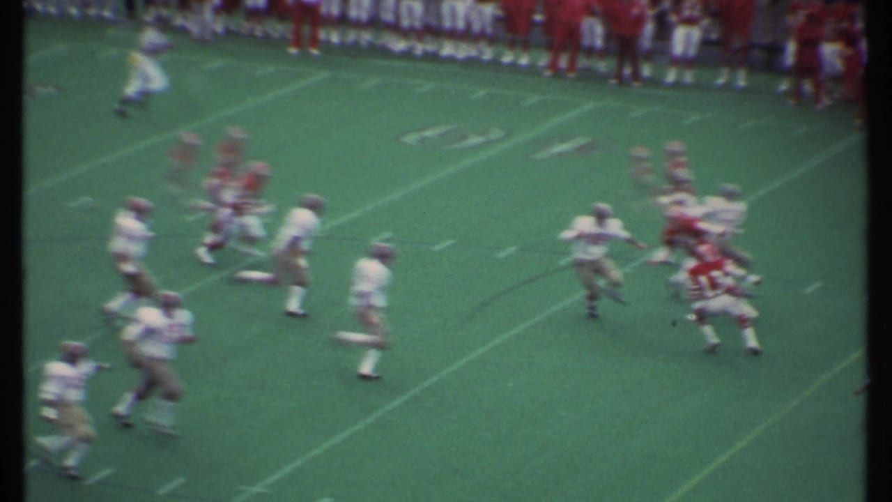 1979 Ithaca football game footage showing red and white uniformed players moving through a play on the field.