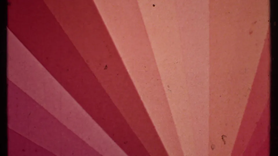 1979 8mm frame with magenta-orange exposure pattern, soft grain, dust specks, and dark frame edge.