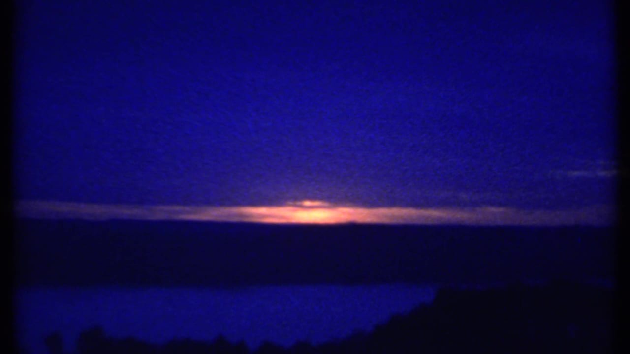 Blue twilight sky with a narrow orange sunset glow over a dark horizon.