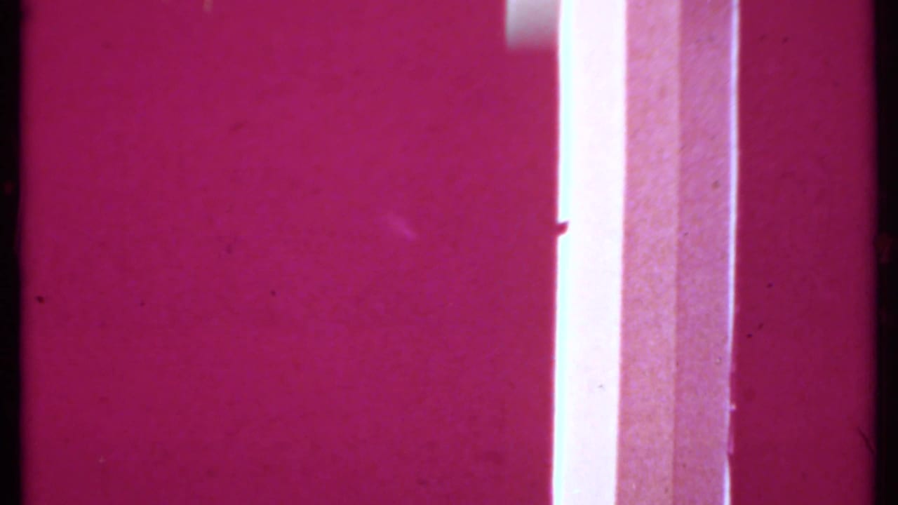 Overexposed magenta 8mm transition frame with a bright vertical strip and visible film texture.