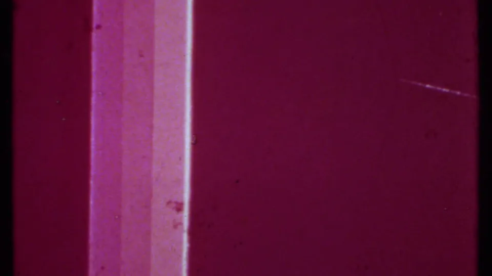 Magenta-red 8mm film-burn frame with a pale vertical band and visible dust marks.