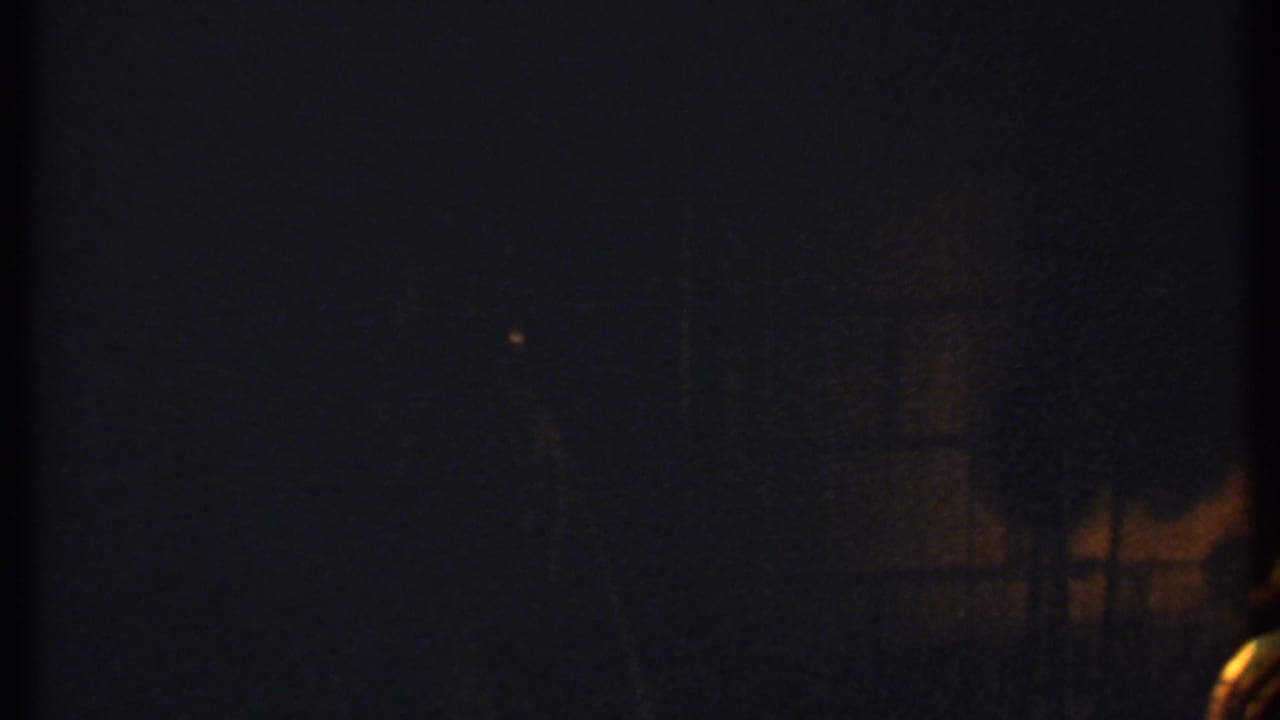 Dark fireplace scene with faint firelight and heavy shadows.