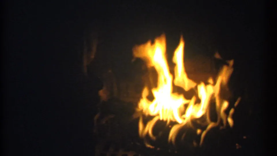 1979 Ithaca 8mm frame showing low flames spread across a dark fireplace, with possible logs or grate shapes visible below.