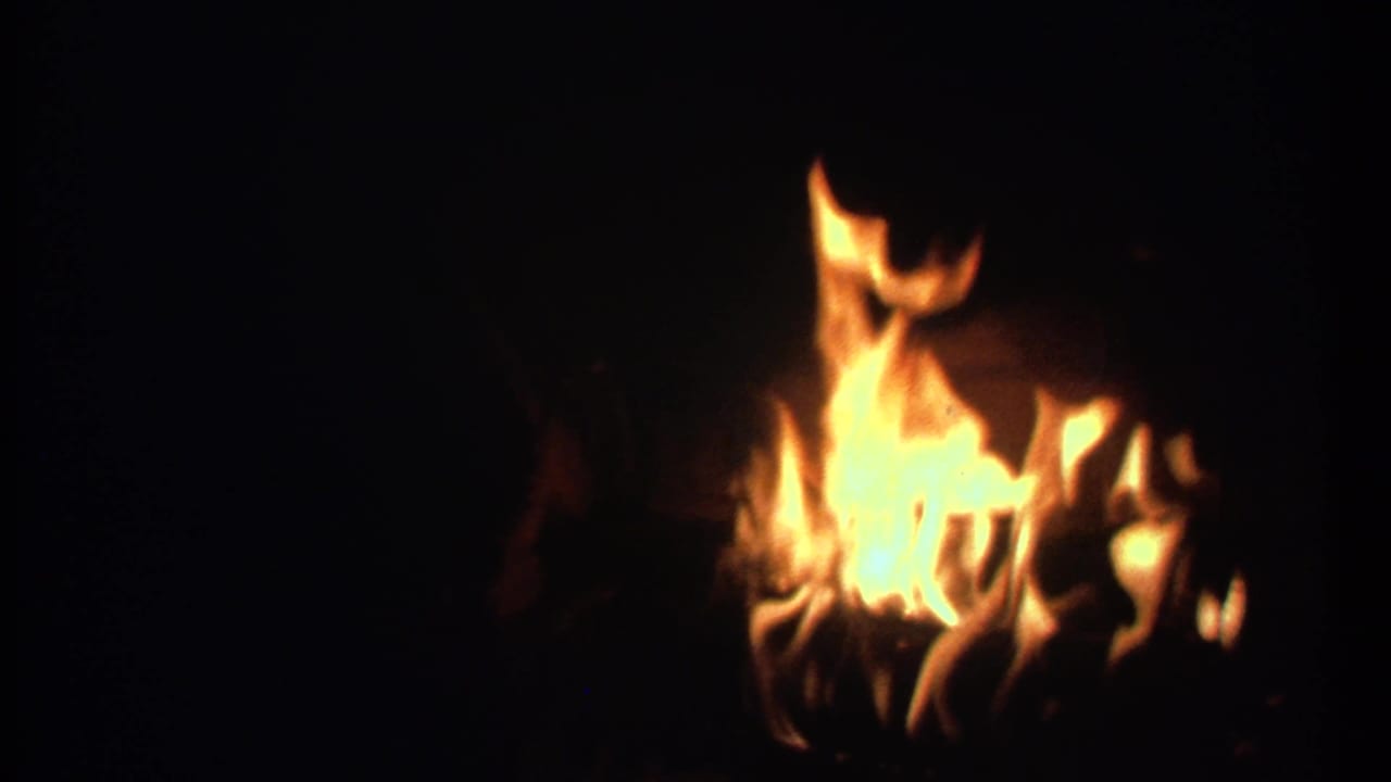 Flames flicker on the right side of a dark frame.