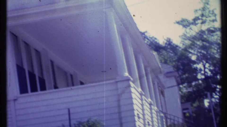The final frame shows a tilted close view of a residential porch exterior, railing, siding, and leafy trees in the background.