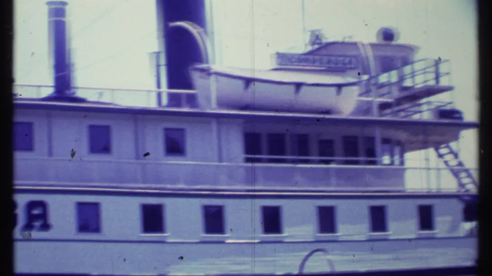 1984 Vermont 8mm frame showing a close section of the steamboat Ticonderoga with white hull, square windows, deck railings, and upper-deck equipment.