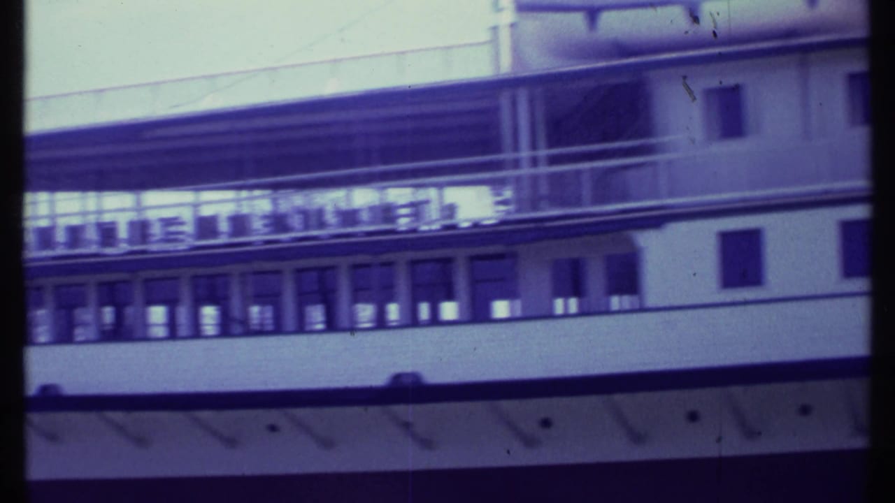 Close view of a white passenger boat with upper deck railings and windows.