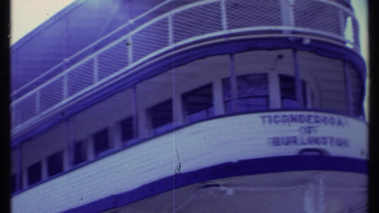 Close view of a white steamboat hull with upper deck railings and a nameplate.