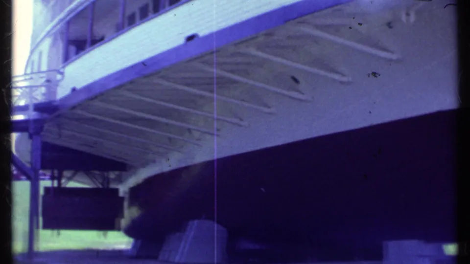 1984 Vermont frame of the vessel's lower hull and underside, with support beams, deck railings, windows, and dark shadow beneath.