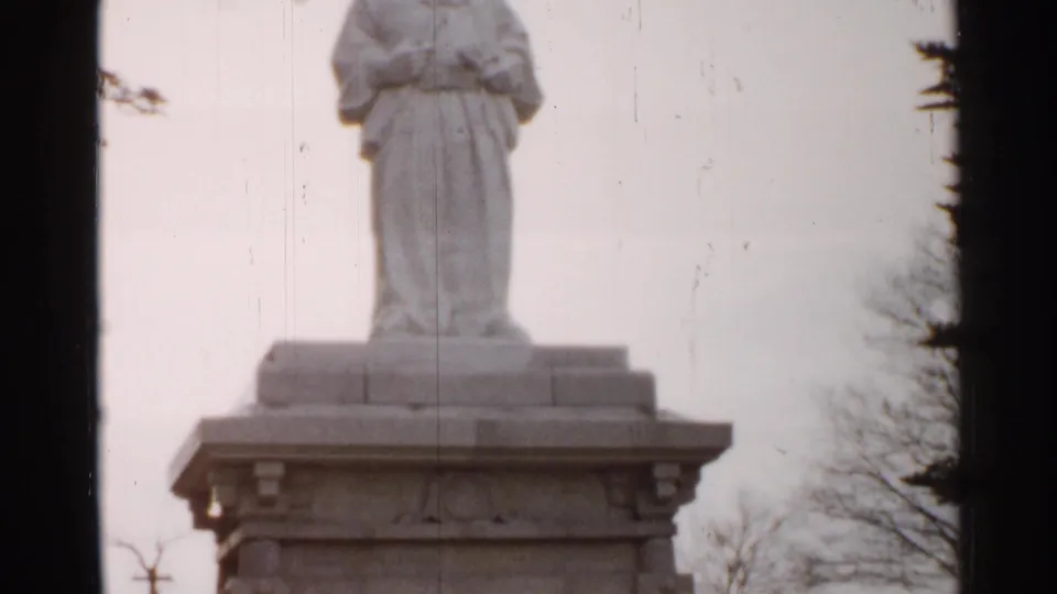 The final frame shows the lower part of the robed stone statue on its pedestal, with trees, pale sky, scratches and 8mm frame edges.