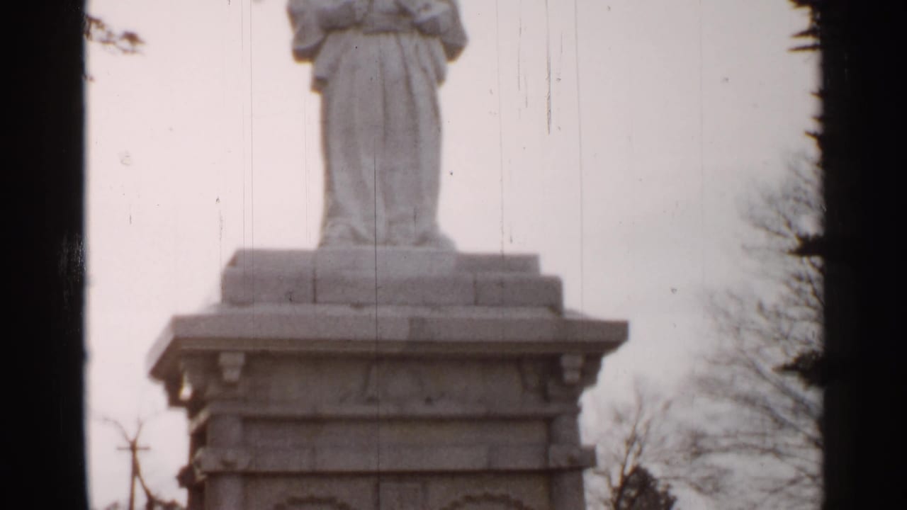 White statue base on a carved pedestal under a cloudy sky.