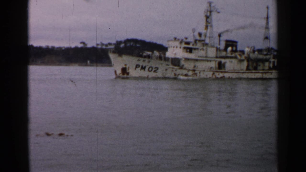 Closer 1952 Japan frame of vessel marked PM02, showing deck equipment, mast details, and small crew figures.