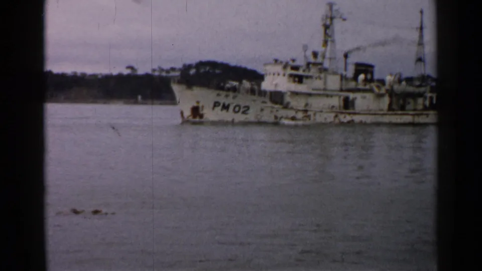 Closer 1952 Japan frame of vessel marked PM02, showing deck equipment, mast details, and small crew figures.