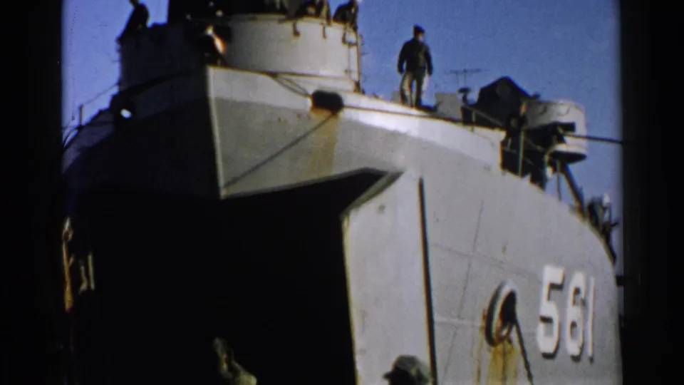 1952 Japan 8mm frame showing a numbered military-looking vessel with men in dark uniforms standing above the bow.