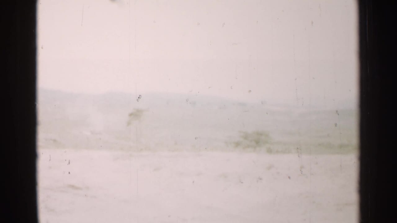 Overexposed mountain landscape seen through a dark window frame.