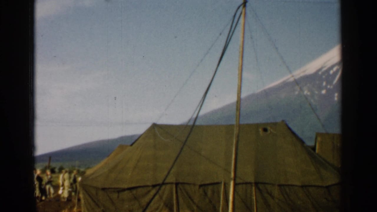 Canvas military tents and poles with Mount Fuji rising behind them.