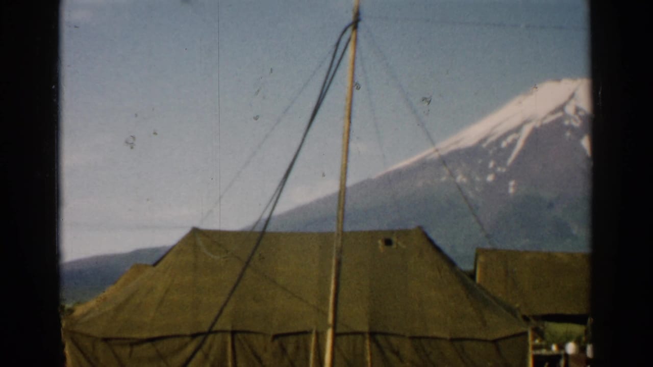 Large canvas tent beneath Mount Fuji with pole lines crossing the sky.