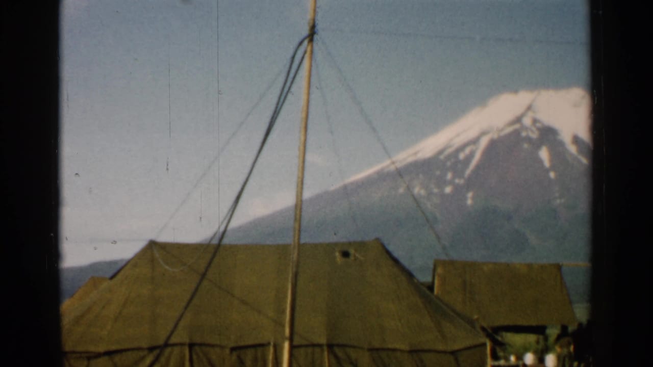 1952 Japan 8mm frame showing a tent roof, crossing support lines, a smaller tent, people at the edge, and Mount Fuji in the background.