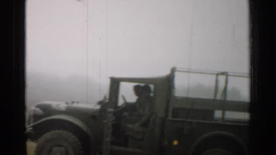 1952 Japan 8mm frame showing an open military truck with occupants moving through foggy conditions.