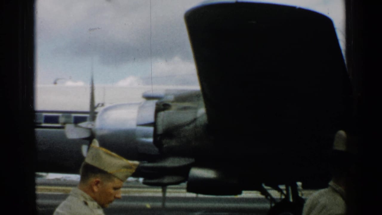 Uniformed men near a propeller aircraft engine on an airfield.