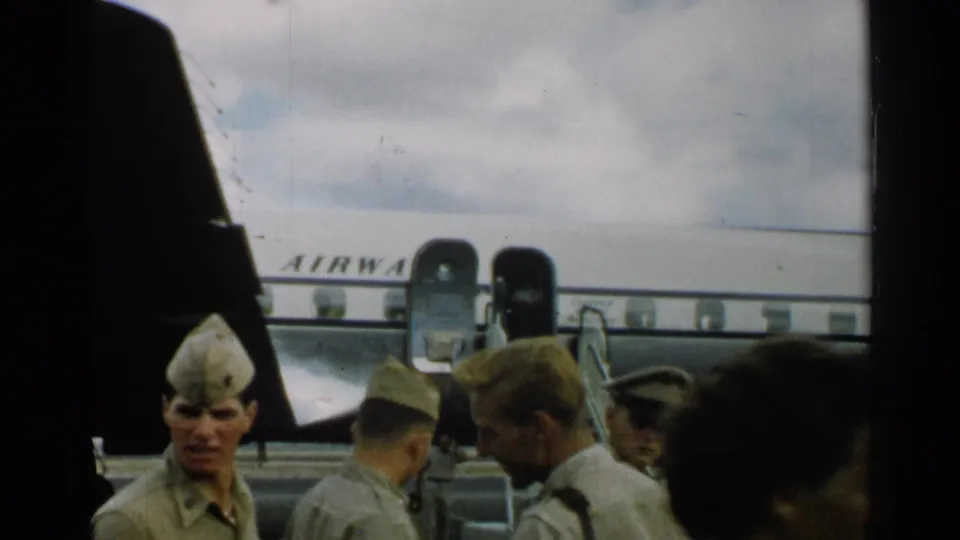 Uniformed personnel and a civilian are seen beside a Pan Am aircraft in the supplied 1952 Japan airport setting.