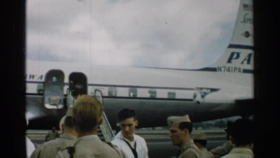 The final frame shows personnel near a Pan Am aircraft tail section, with partial registration text visible in the 1952 Japan home-movie footage.
