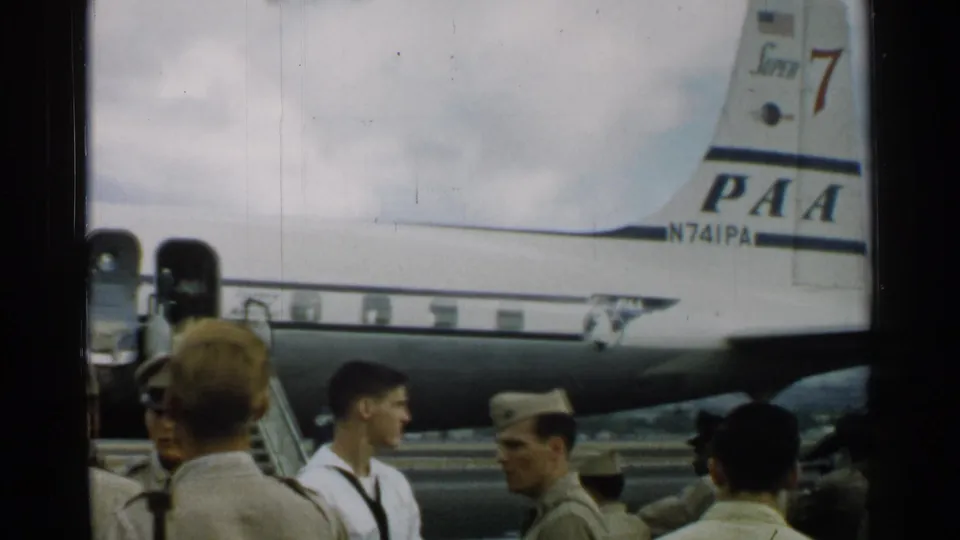 In 1952 Japan, sailors and airmen gather near a Pan American aircraft tail marked PAA and N741PA.