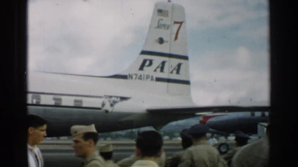 The PAA aircraft tail and registration N741PA dominate the 1952 Japan tarmac view, with uniformed men below.