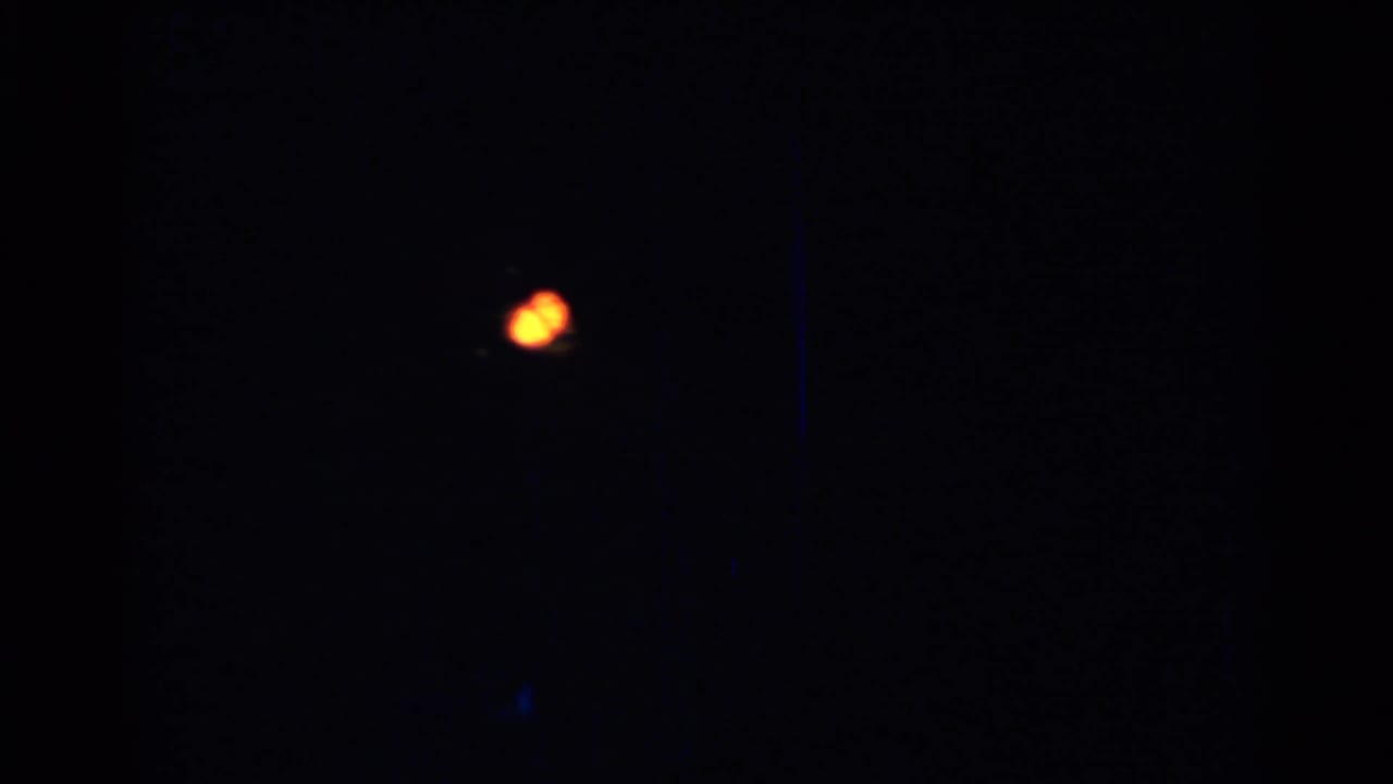 Dark frame with a small out-of-focus warm Christmas light.