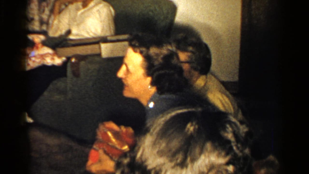 Women seated indoors during a family gathering, with one woman laughing near the foreground.