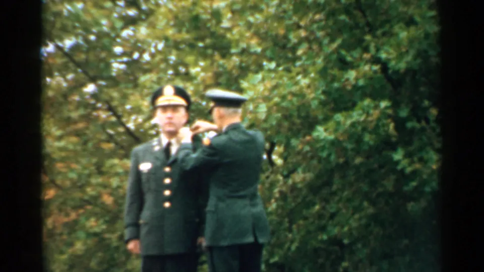 At the end of the clip, the officer remains close to the soldier's lapel during the New Hampshire military recognition moment.