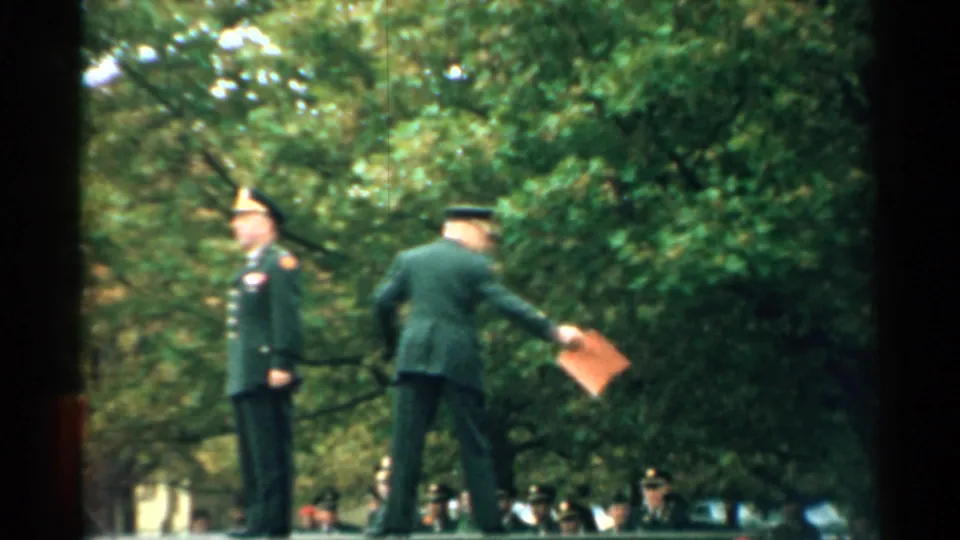 At the end of the New Hampshire ceremony clip, one uniformed man steps away with a folder as the other remains standing.