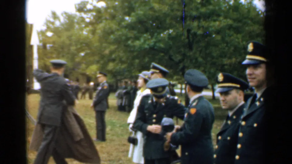 Uniformed officers at a 1952 New Hampshire outdoor military ceremony, with cameras and spectators visible in the park.