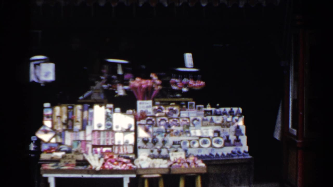 Street display of boxed souvenirs, figurines, and small colorful items.