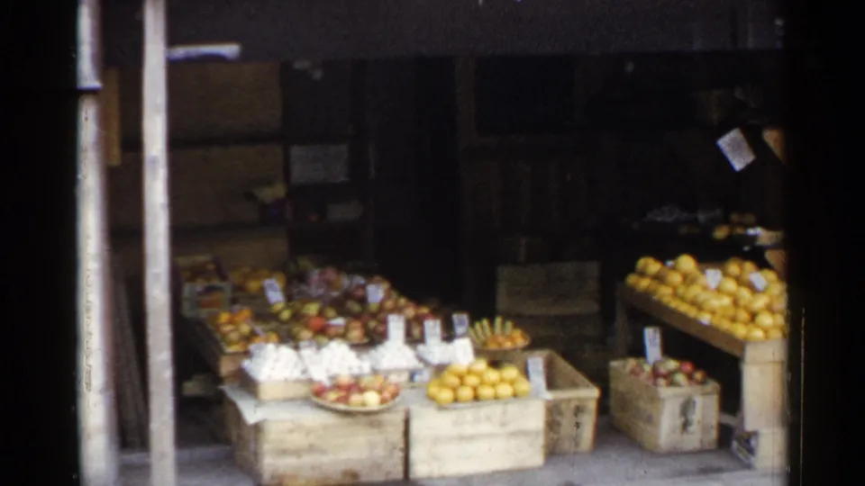 1953 Japan street produce display with stacked citrus, apples, baskets, price cards, and wooden crates along the storefront.
