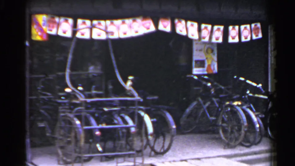 1953 Japan nighttime storefront with several bicycles parked below lanterns and a visible wall poster.