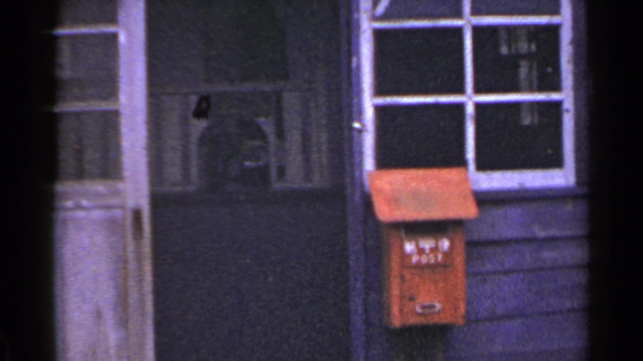 Wooden post office exterior with doorway, window, red mailbox, and partial sign.