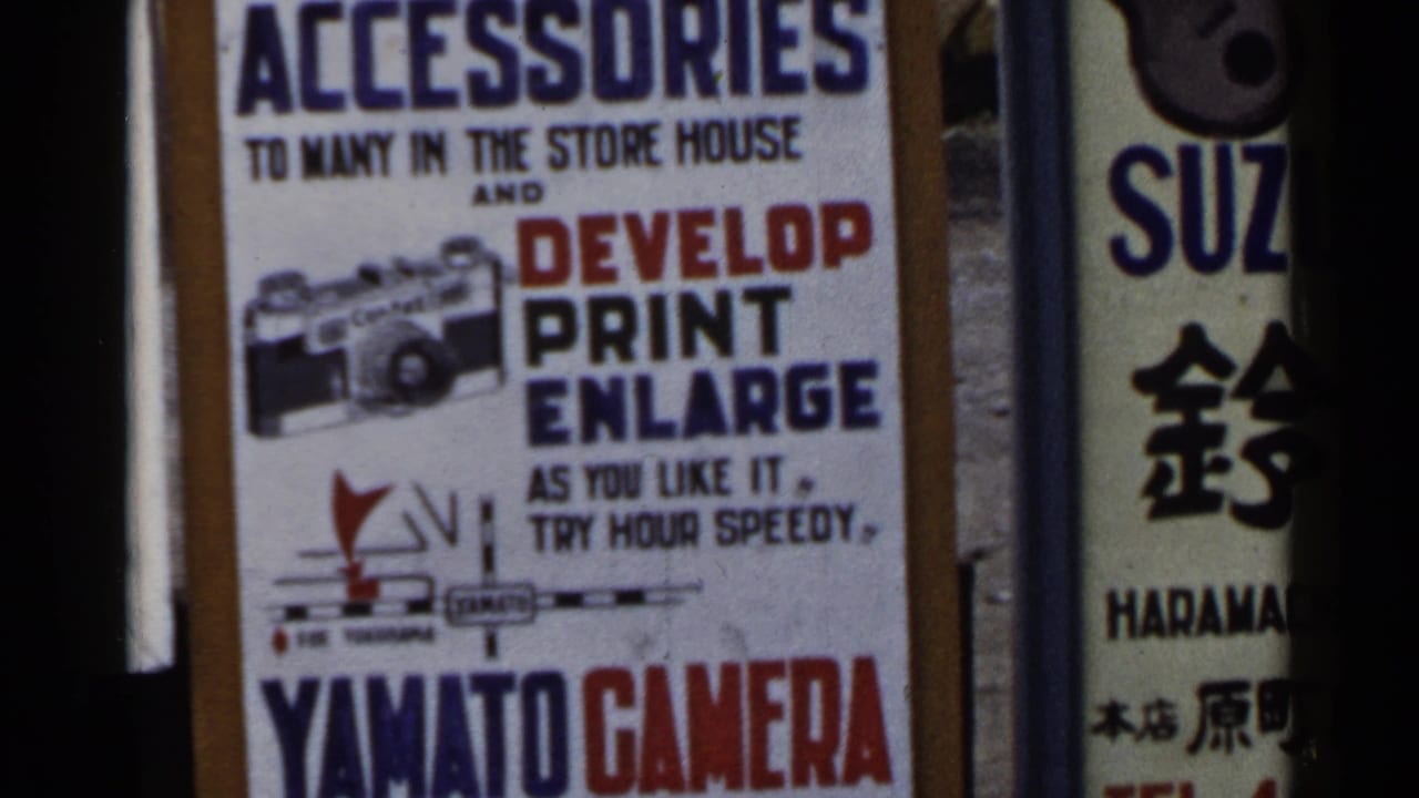 Close view of Yamato Camera sign beside a vertical Suzuki sign with Japanese text.