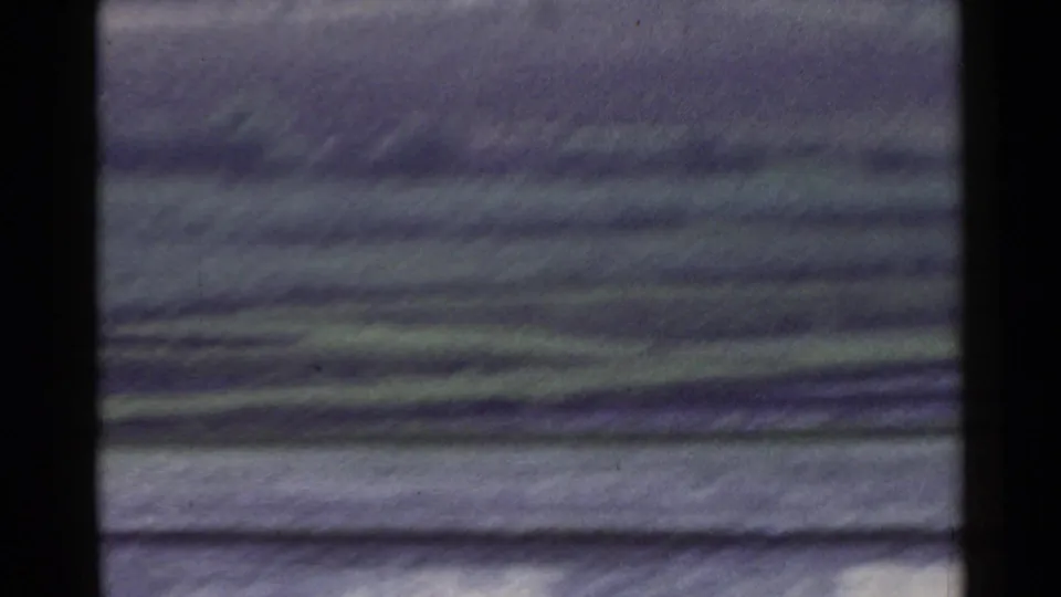 1953 Japan 8mm frame showing layered green and gray field bands, with motion softness and visible archival film texture.