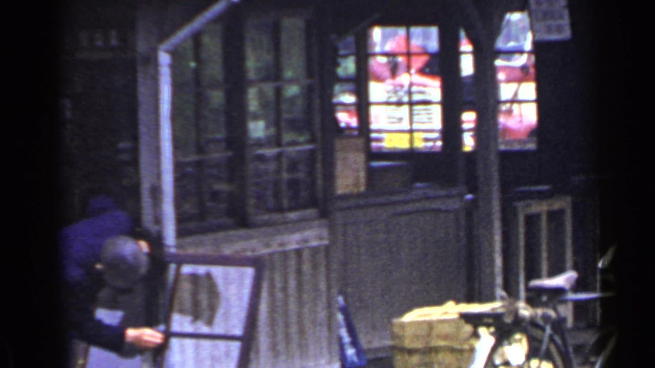 Wooden building front with windows, posted signs, bicycle, and a person partly visible at left.
