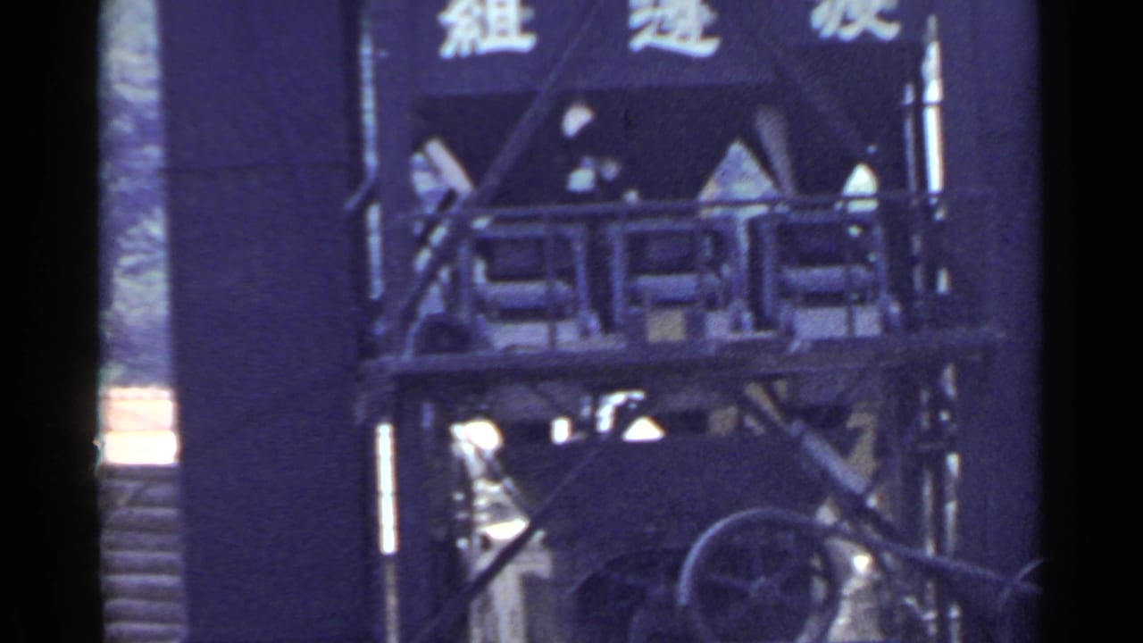 Tall Japanese industrial structure with visible characters, railings, and machine parts, filmed in 1953-era 8mm color.