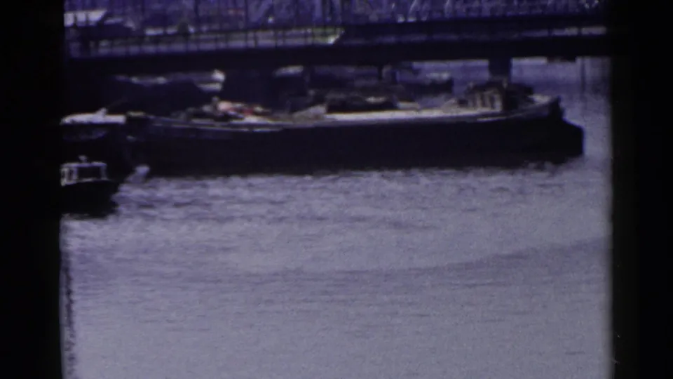 Vintage 1953 Japan 8mm frame showing a moored boat beneath a bridge, with still water and dark film-edge framing.