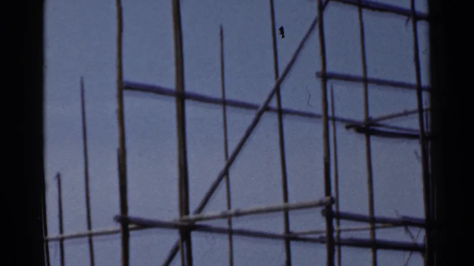 1953 Japan 8mm frame showing dense construction scaffolding with no clearly visible worker in this crop.