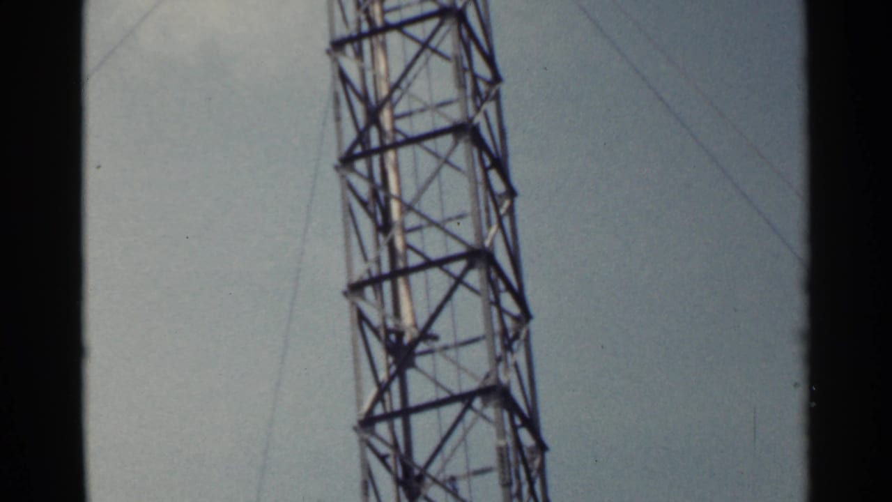 Tall metal lattice tower rising against a pale sky.